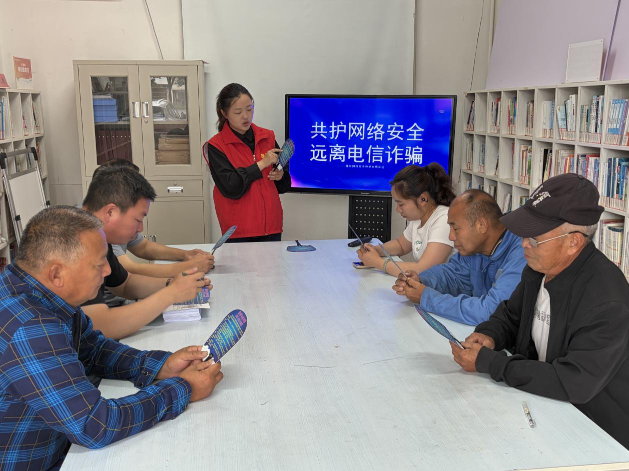 网络安全志愿者给村民讲解常见通讯网络诈骗手法(左亚军 摄)