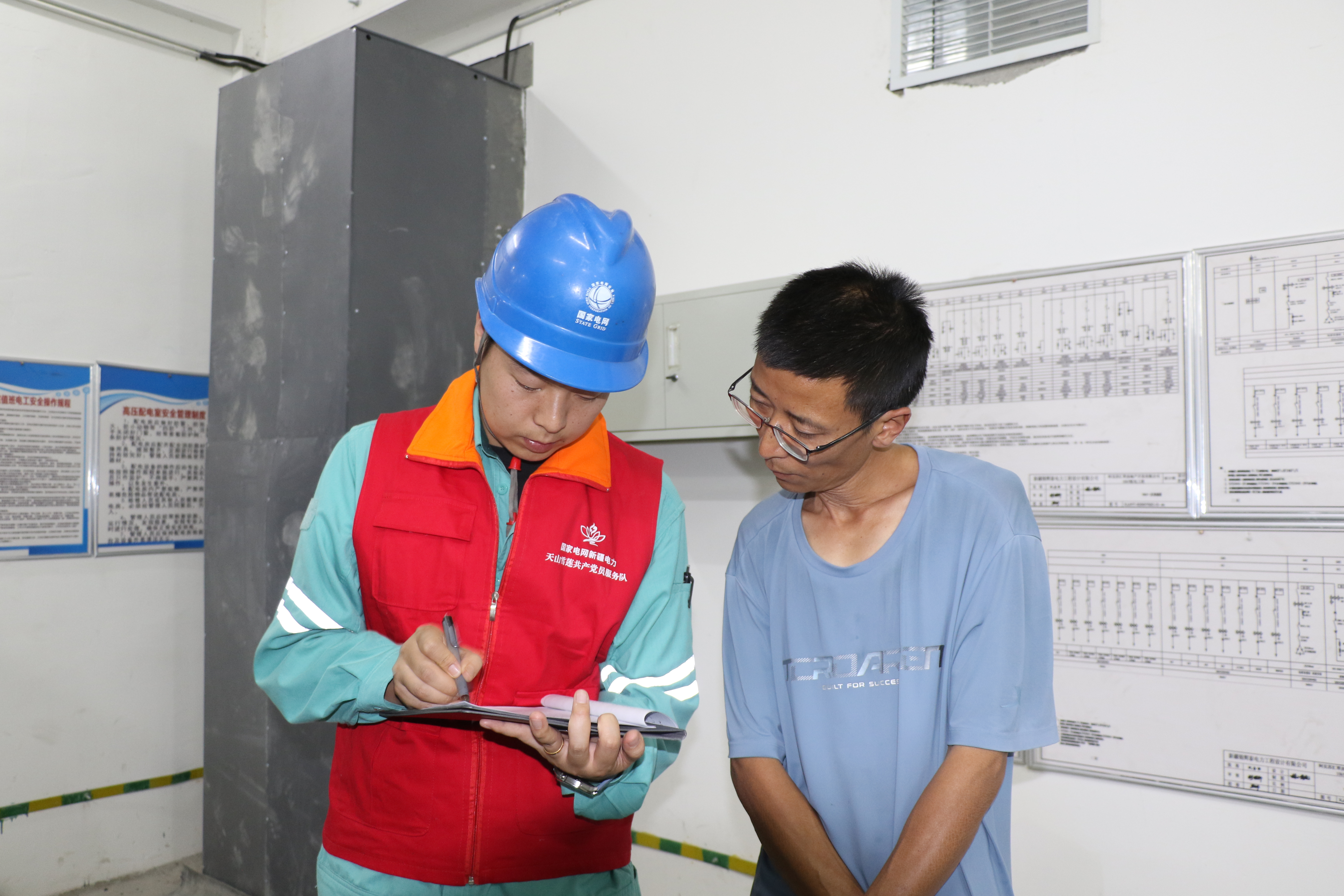 国网阿克苏供电公司工作人员在阿克苏市众恒公园城3期,对充电桩配套变压器开展专项检查验收,并为施工人员提供技术指导。(邸敏 摄)