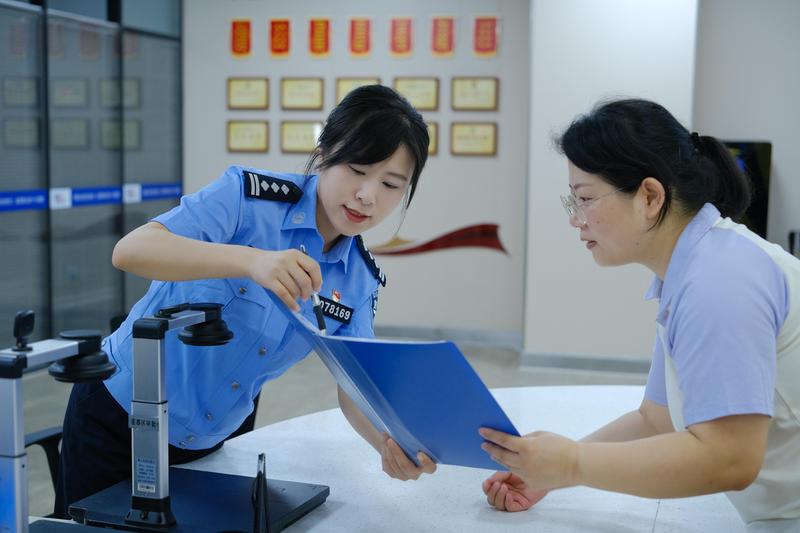 周莹(左)接待群众咨询办事现场(胡昌清 摄)