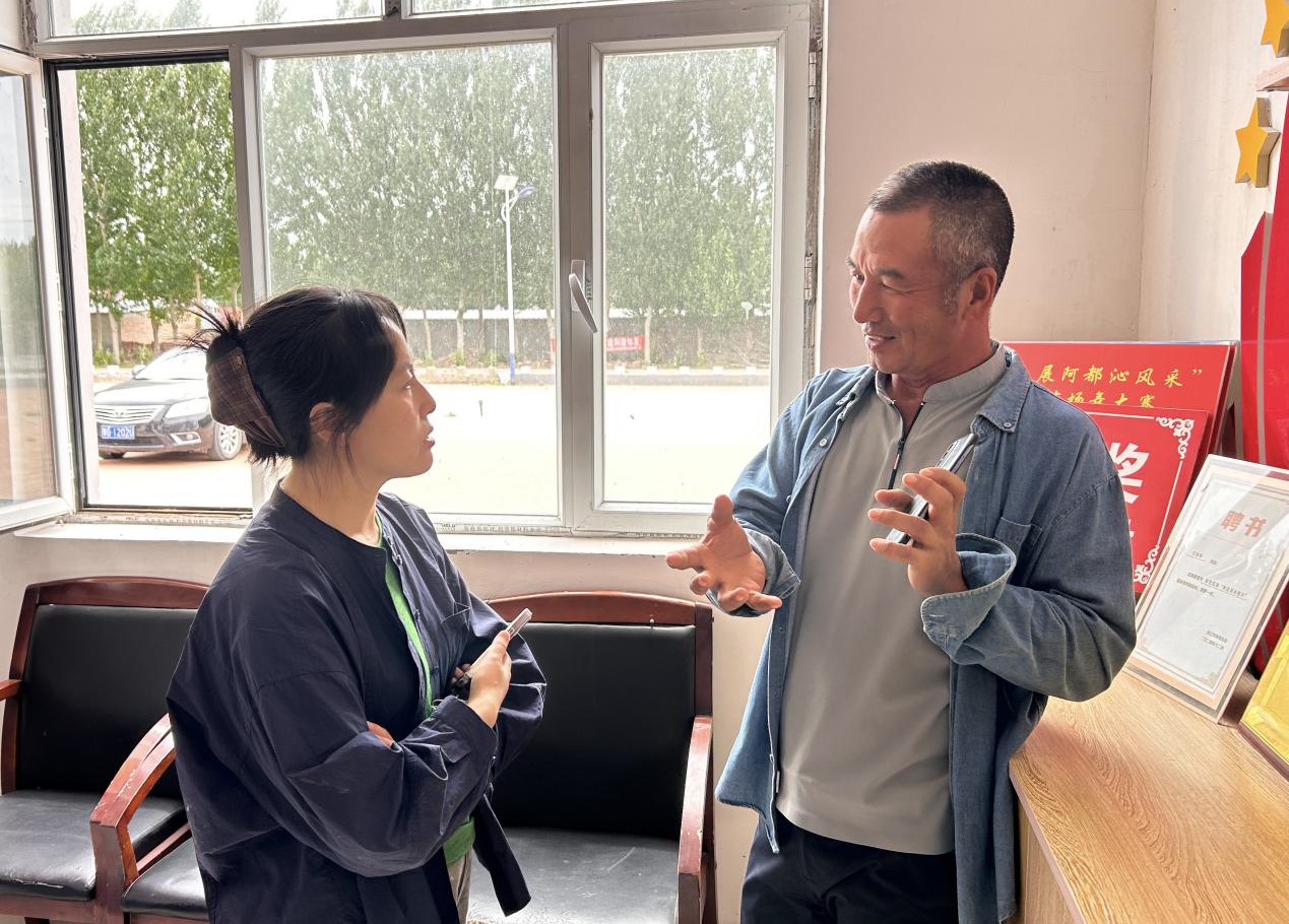 阿都沁苏木乌兰牧骑团长王金海(右)接受采访(李智杰 摄)