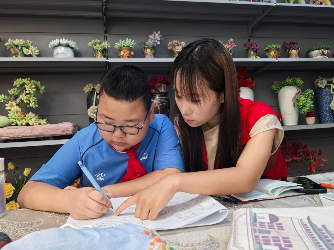 志愿者正在暑期爱心托管班上辅导学生(杜福建 摄)