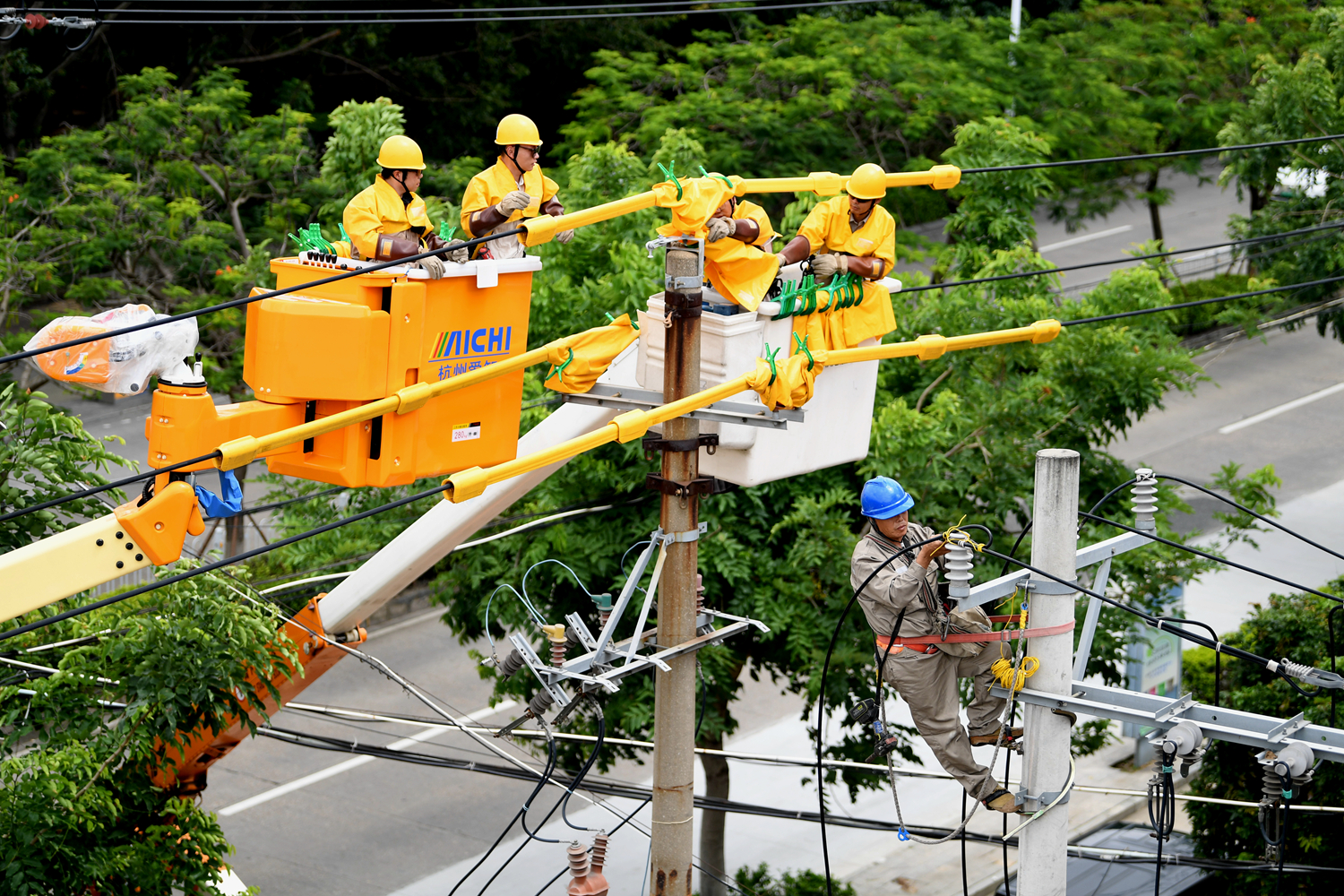 7月20日,晋江市最高气温达33摄氏度,国网晋江市供电公司采用带电作业与停电施工相结合方式,对110千伏内江变10千伏华泰I回进行升级改造,确保居民清凉度夏。(游劲松 摄)