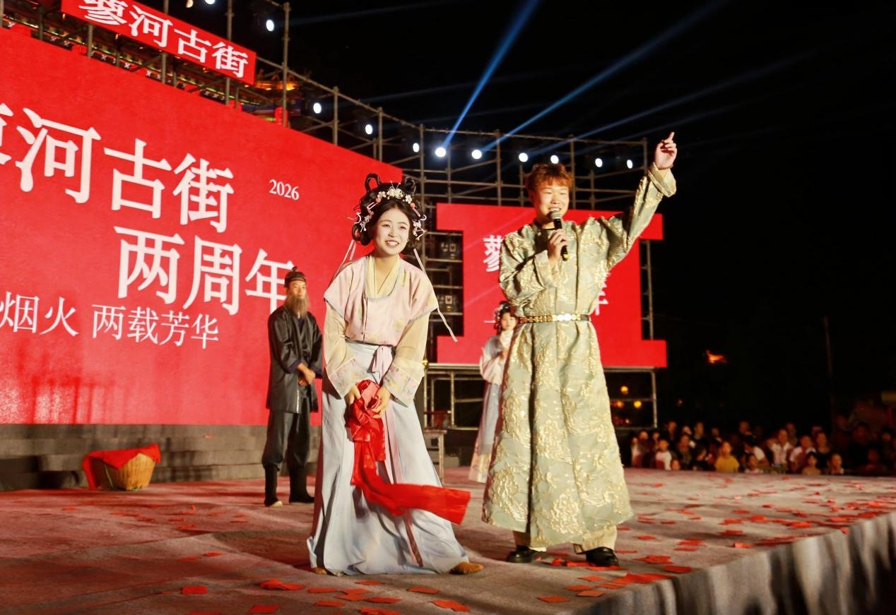 身着古风服饰的主持人登台互动,以国风韵味串联整场蓼河古街两周年庆典,向台下游人送上诚挚问候。(王鹏 摄)