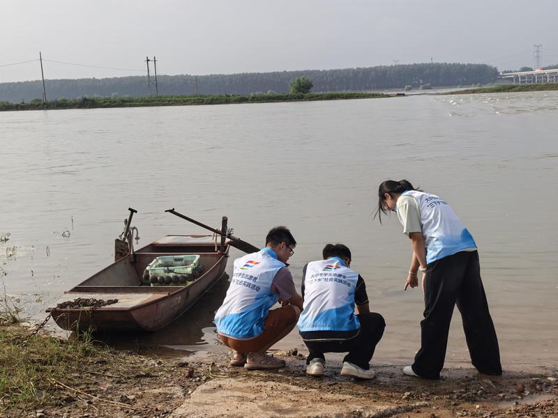 实践团成员在当地颐和湖开展水域调研,采集水样(邱麒睿 摄)