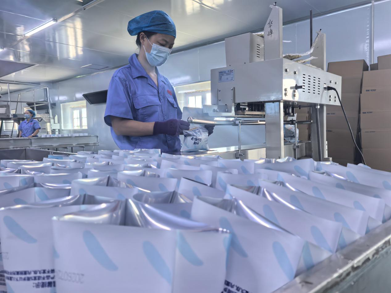 新疆华峰食品科技有限公司生产车间工人正在包装休闲食品瓜子。(马月 摄)