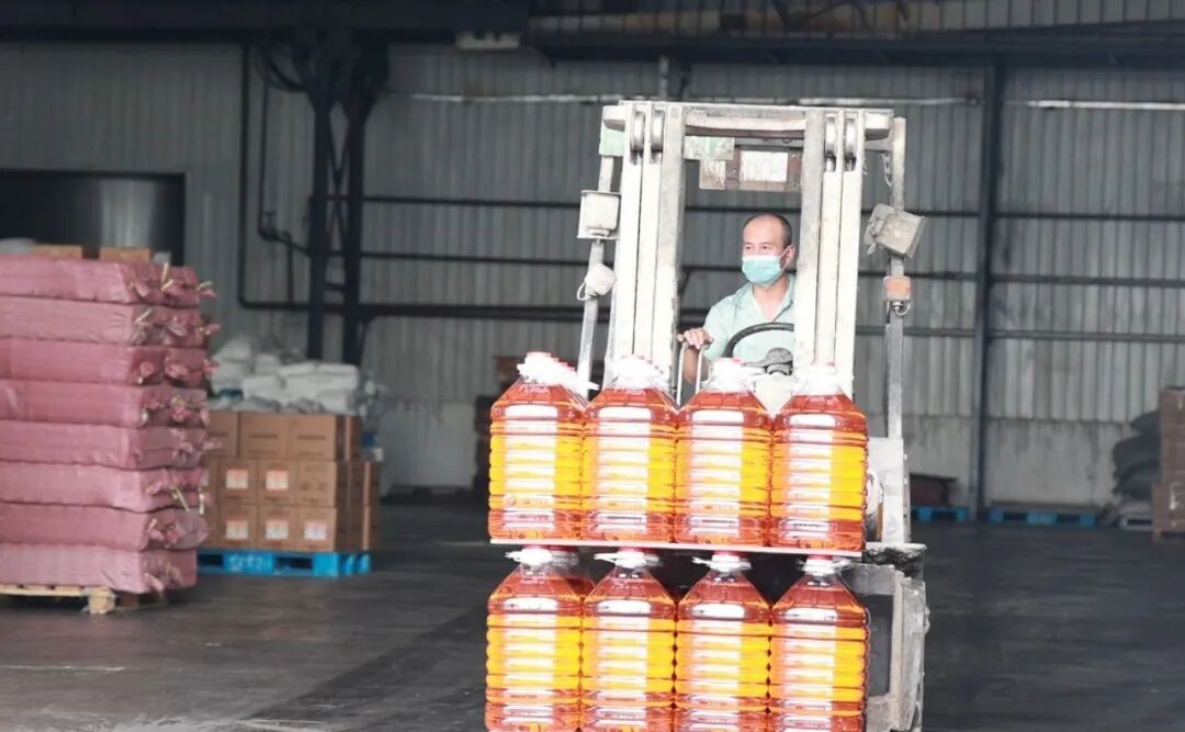 工人驾驶叉车转运桶装食用油 (格日乐图 摄)