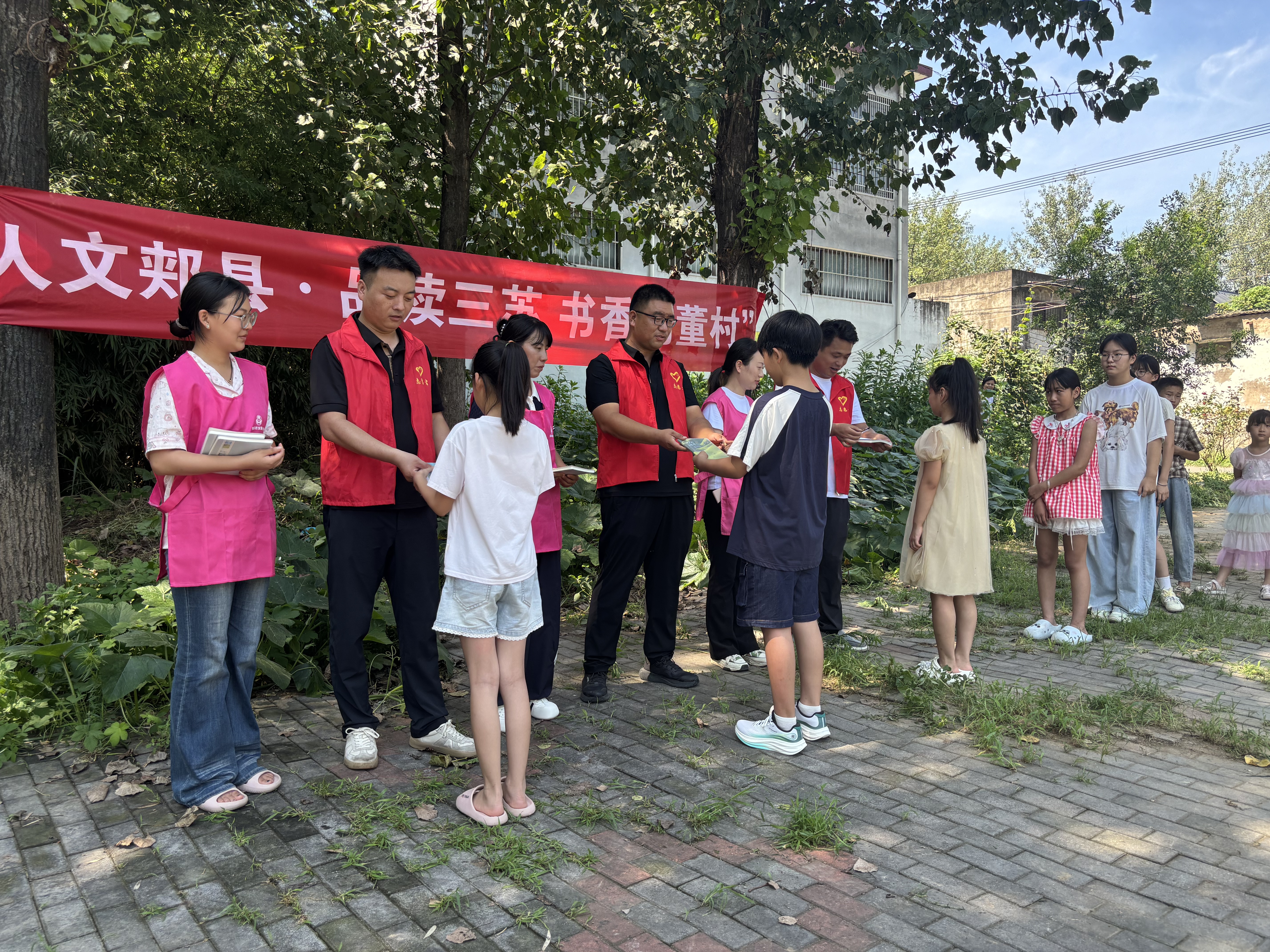 村两委干部与志愿者为孩子们颁发学习礼品,激励书香成长(侯兵摄)