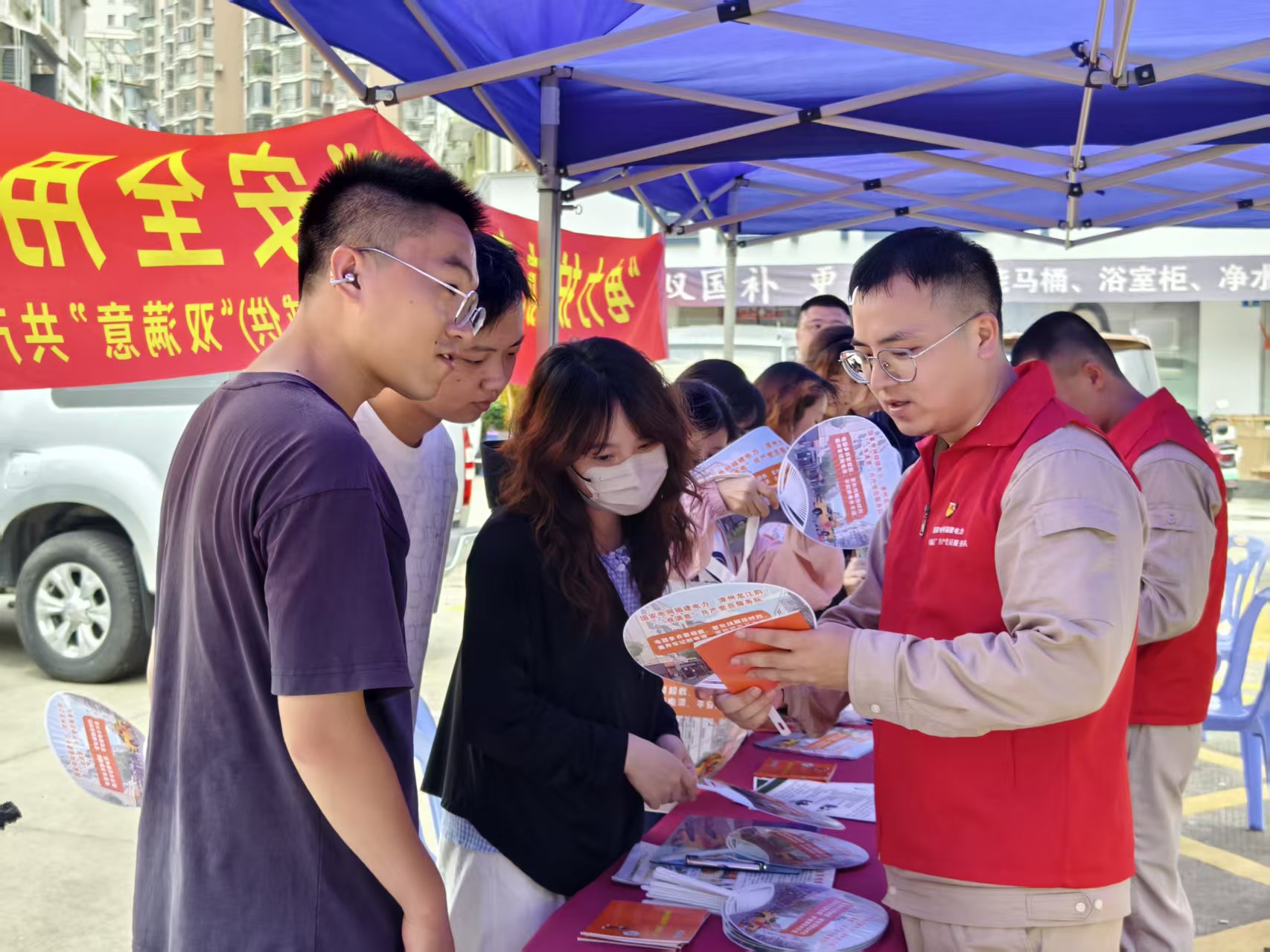 7月30日,国网漳州供电公司新桥供电站站长沈学宇在摊位前为居民普及用电安全知识。(林钰芳 摄)