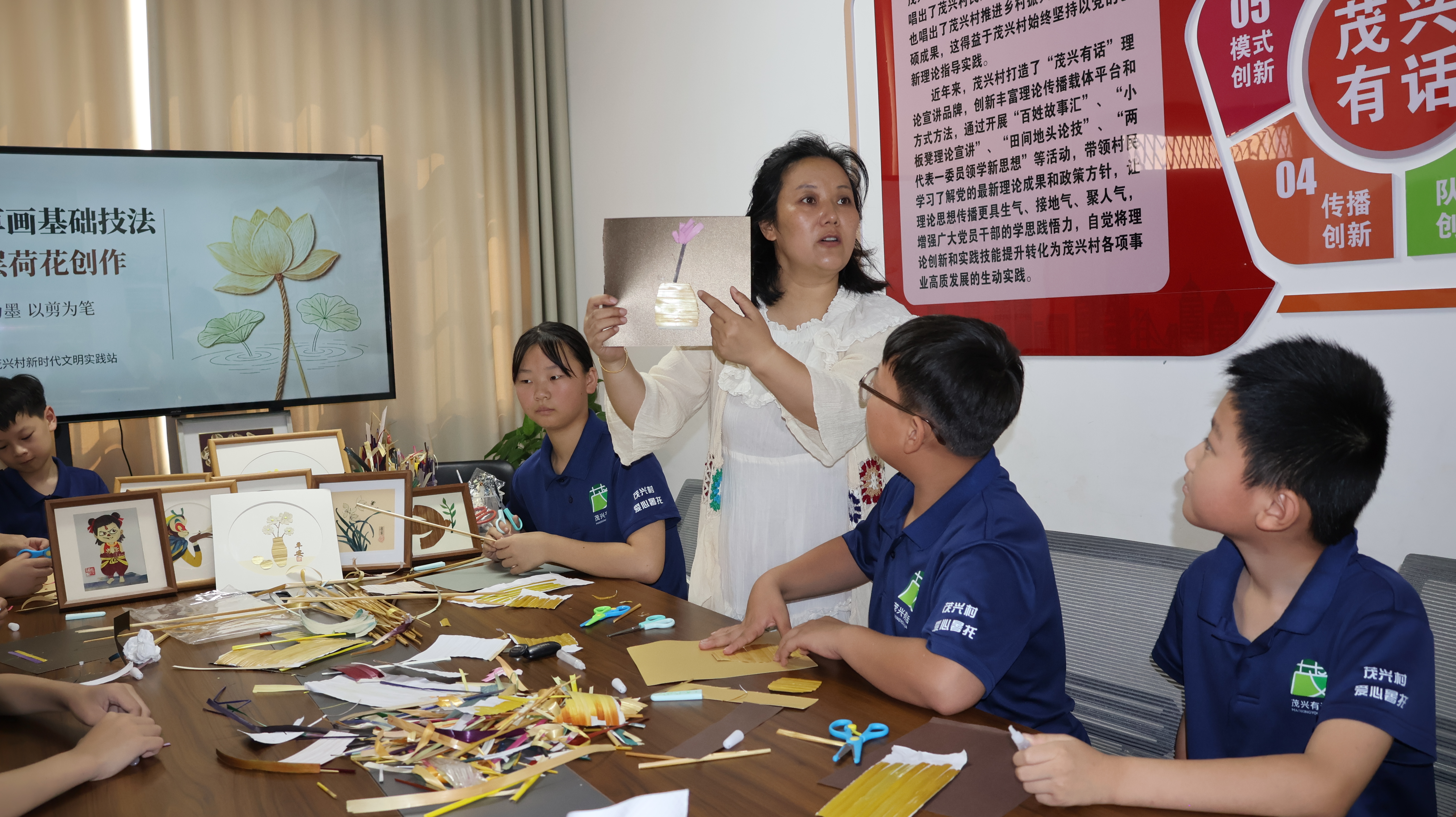 连云港市麦草画非遗代表性传承人胡成娟向孩子们传授麦草画制作技能。(王华 摄)
