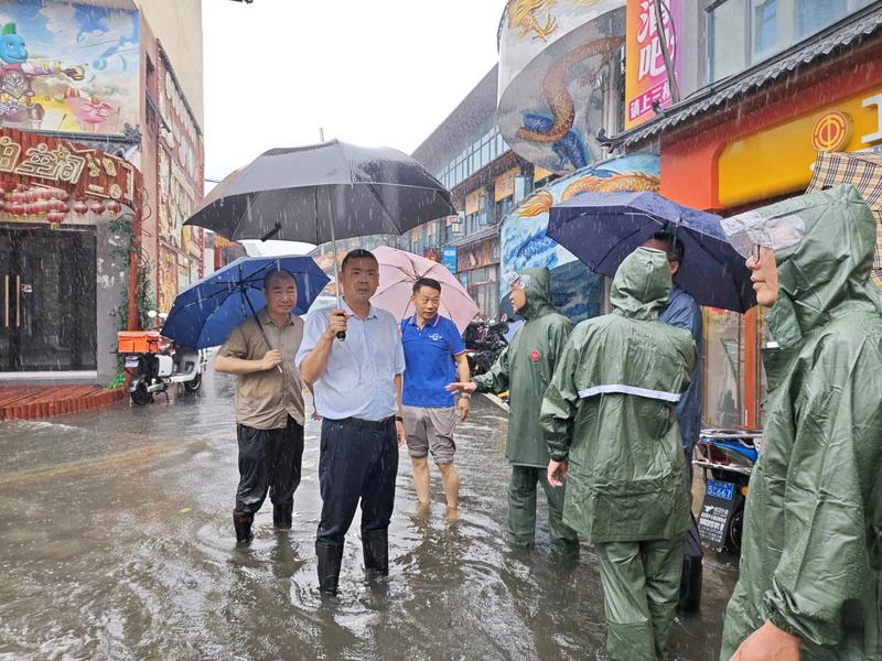 樊城区委副书记、代理区长王平武(左2)深入一线察看各地排水疏通情况(张晶 摄)