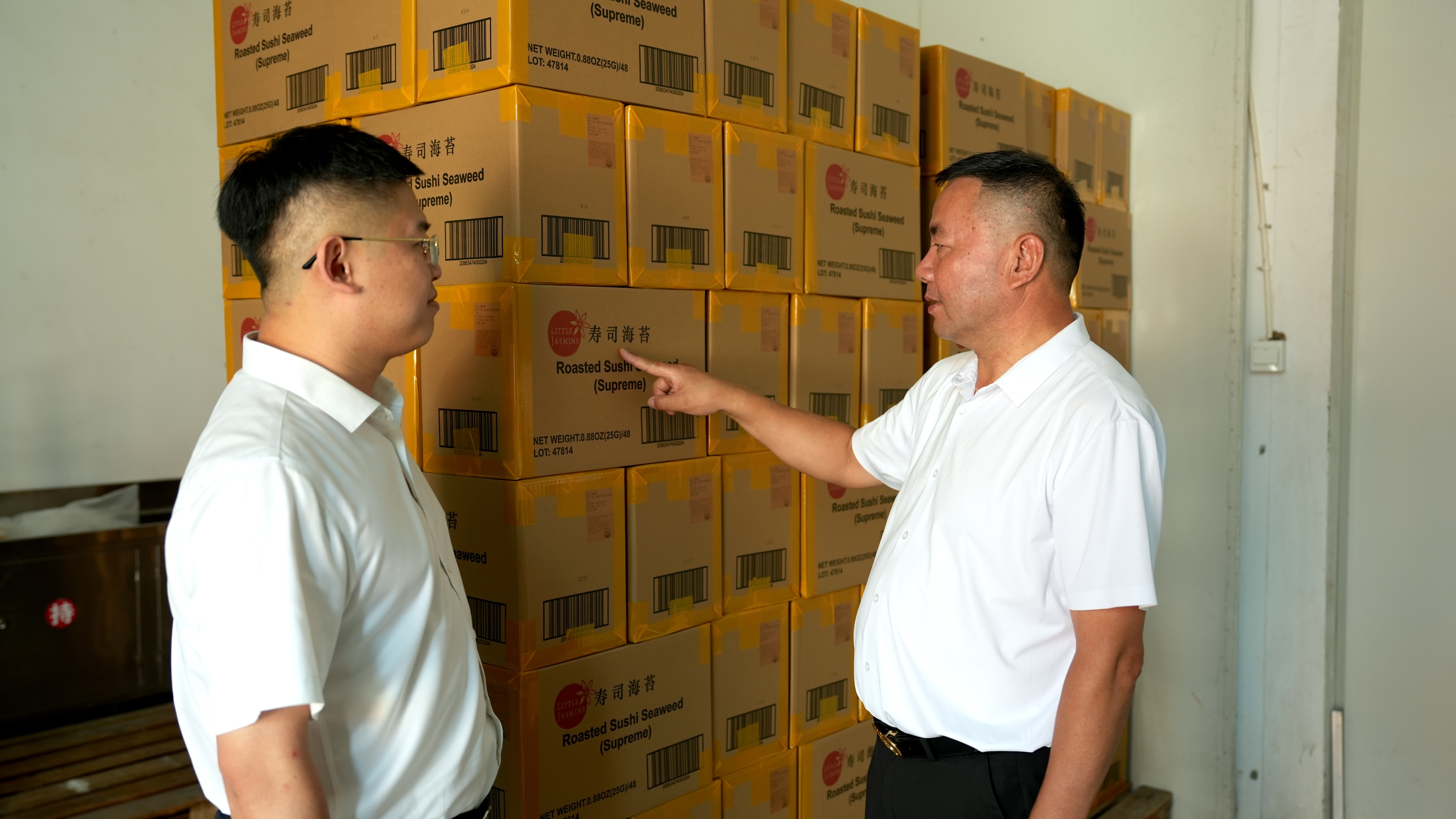 华信食品董事长陈海华(右一)向启东农商银行工作人员介绍企业产品 (丛伯地 摄)