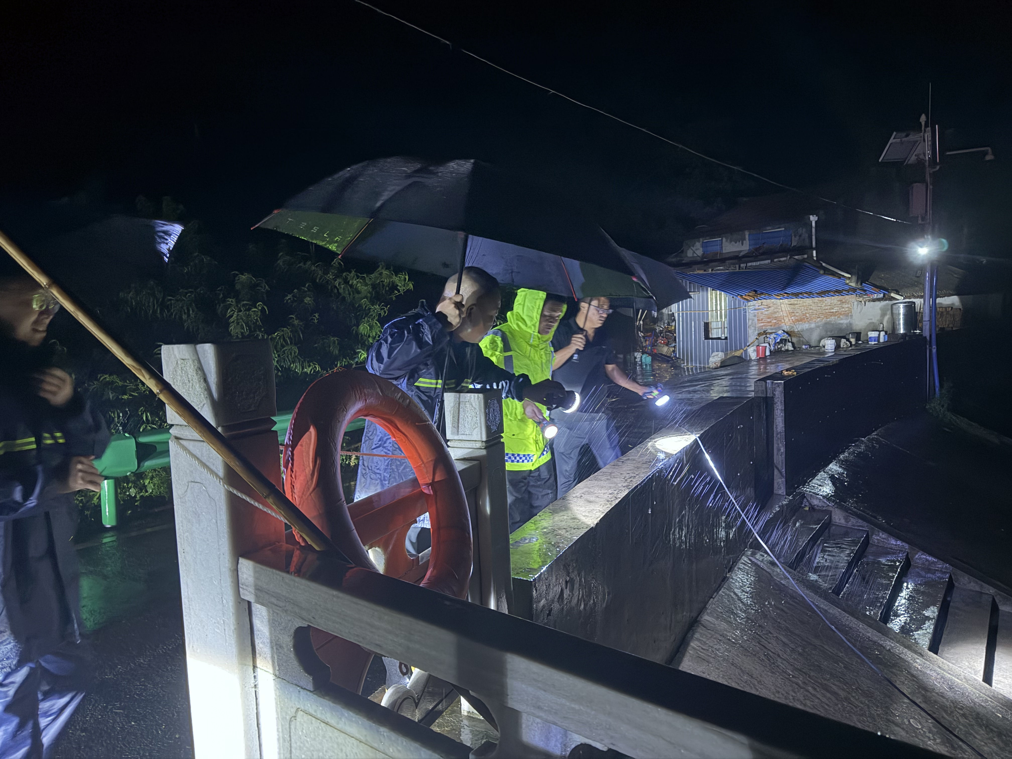驻守在任湾水库的太平店镇党员干部冒雨挑灯夜战(王晓丽 摄)