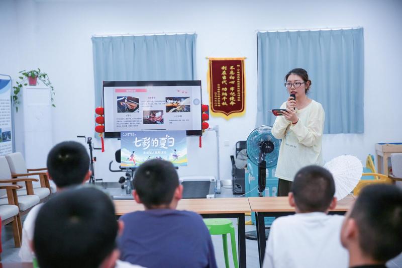 志愿者指导孩子们自己动手绘制伞面(徐慧 摄)