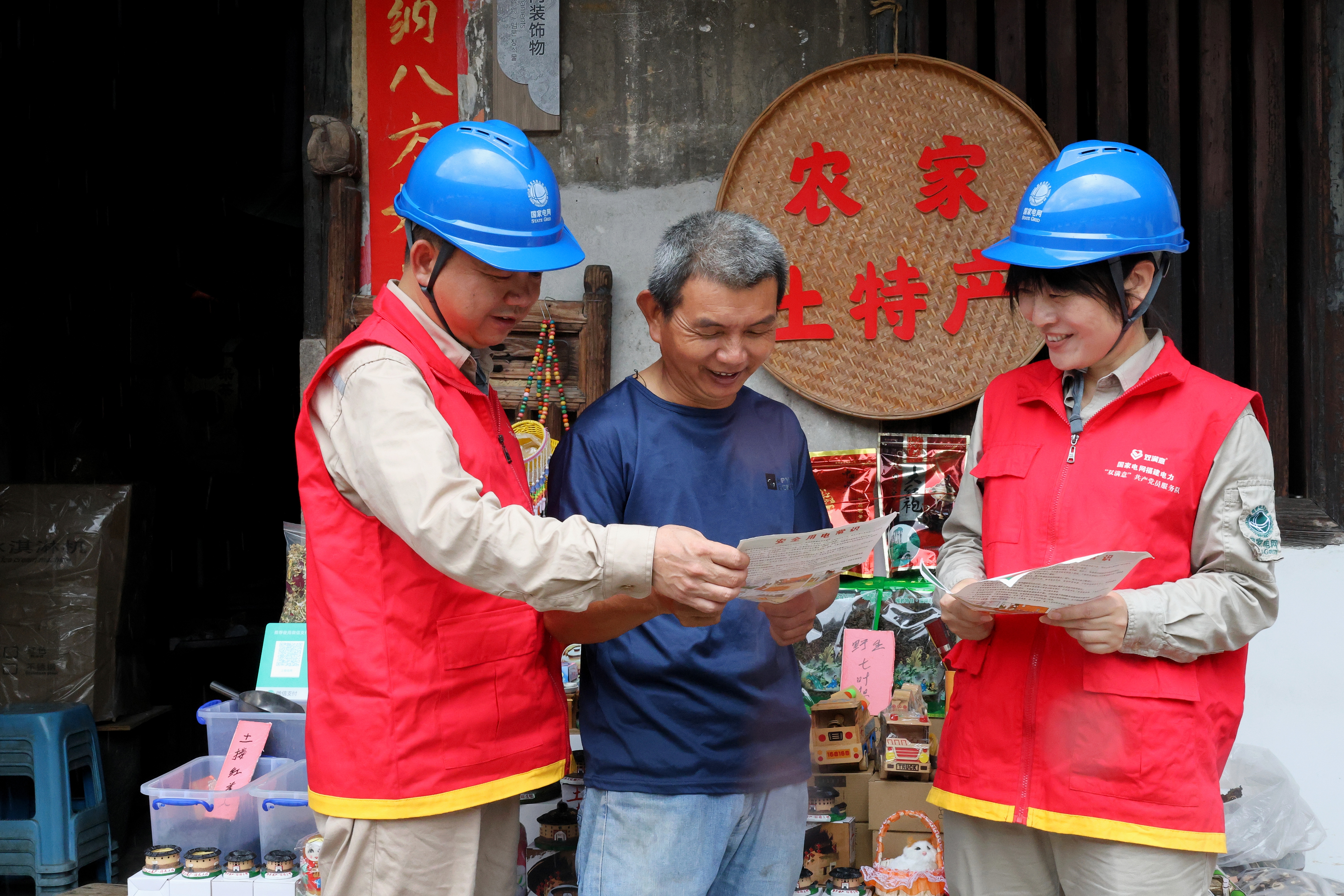 国家电网福建电力(华安龙江韵)“双满意”共产党员服务队为土楼居民宣传安全用电常识。(邹惠燕 摄)