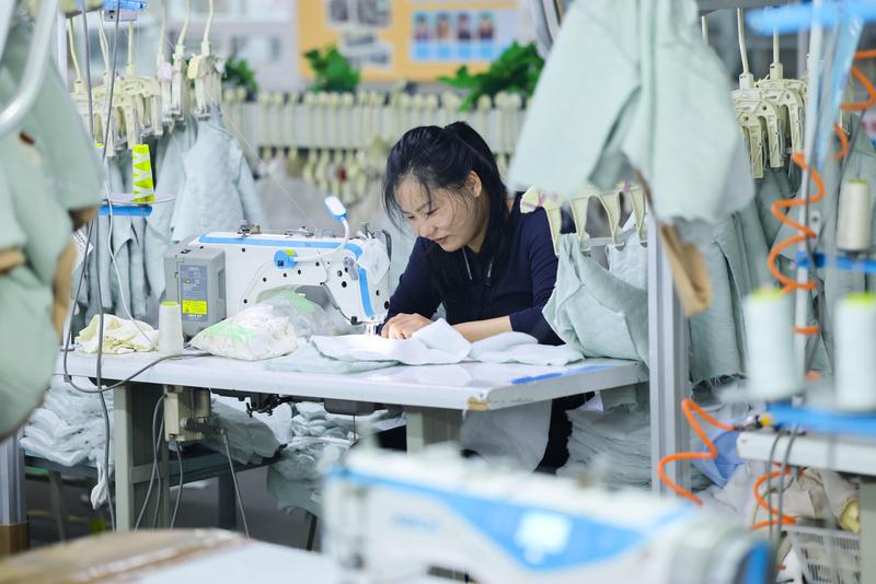 8月13日赣榆区赣马镇连云港东怡时装有限公司的工人在生产出口到海外市场的成衣产品。(司伟 摄)