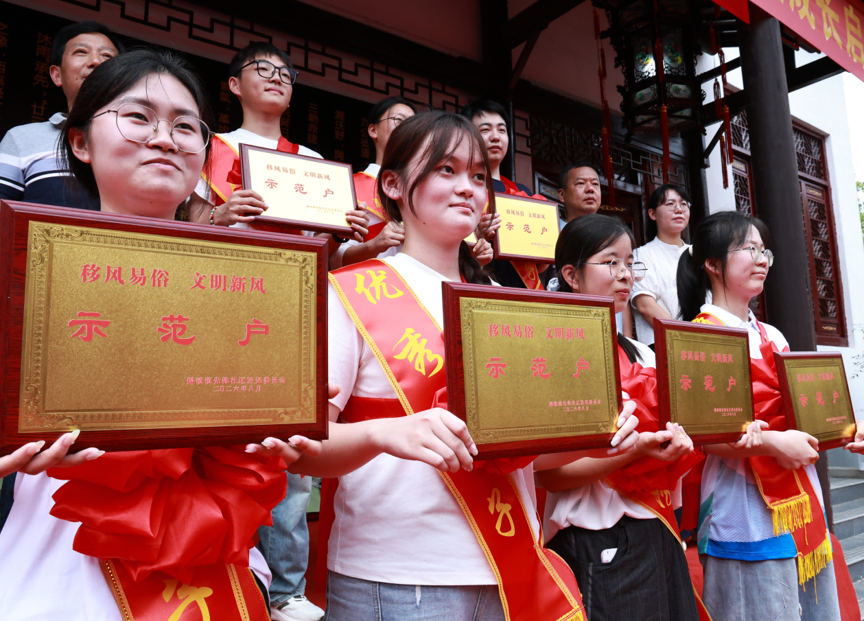 先锋社区为准大学生家庭颁发移风易俗示范户标牌(彭红玲 摄)
