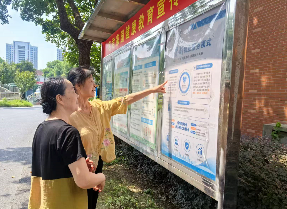 居民驻足查看名君家园“信管制”物业服务模式宣传栏(孙雨静 摄)