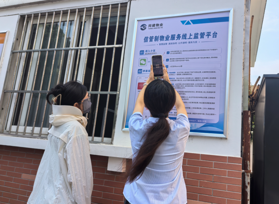工作人员现场指导居民扫码体验信管制物业服务线上监管平台(孙雨静 摄)