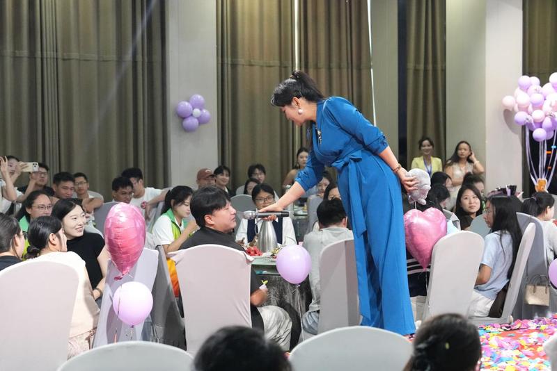 主持人俯身与现场青年互动交流,氛围轻松融洽。(梁可坤 摄)
