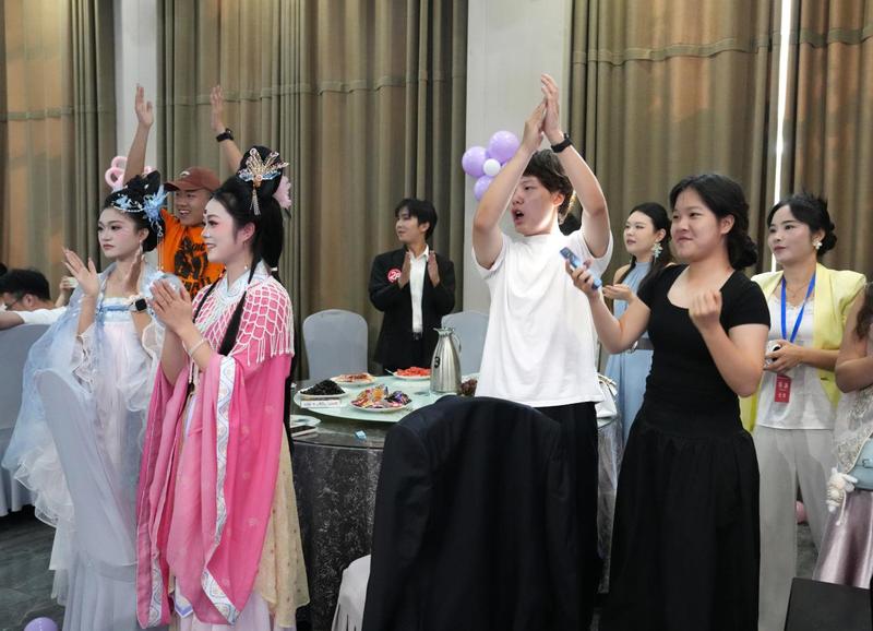 参与联谊活动的青年兴致高涨,鼓掌互动,现场气氛热烈欢快。(梁可坤 摄)