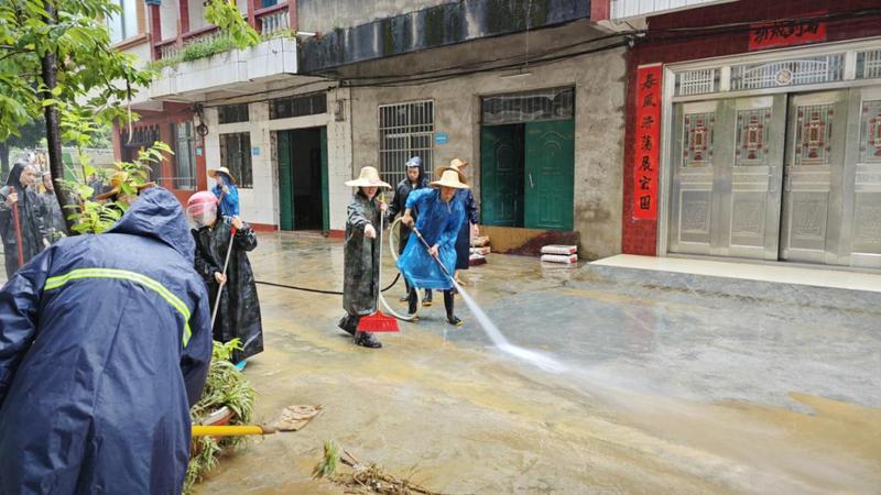 凭祥市党员干部手持水枪在华侨小区开展清淤工作(农华艳 摄)