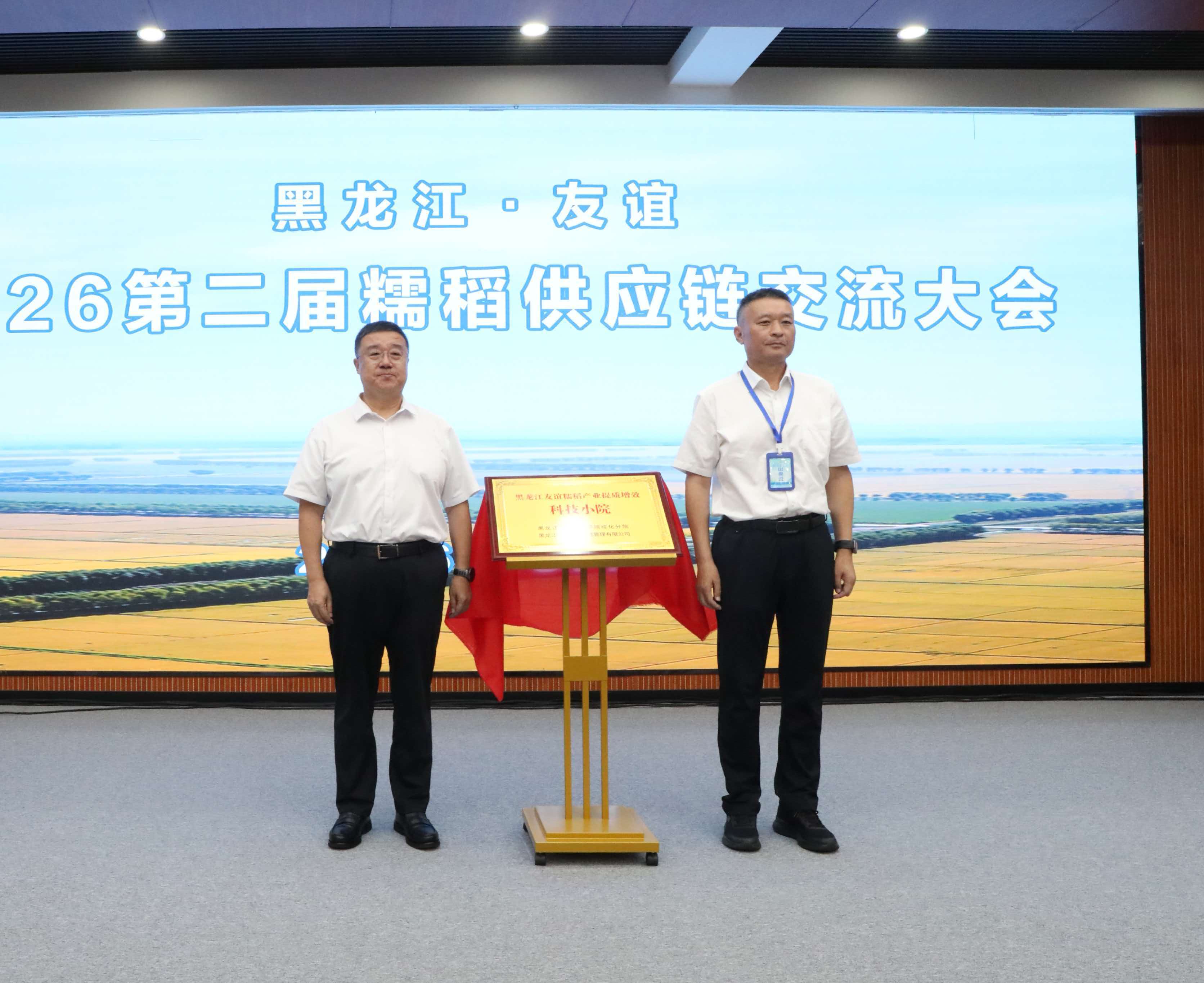 友谊县委书记李伟(左)、黑龙江省农业科学院绥化分院副院长聂守军(右)为黑龙江友谊糯稻产业提质增效科技小院揭牌(刘海彬 摄)