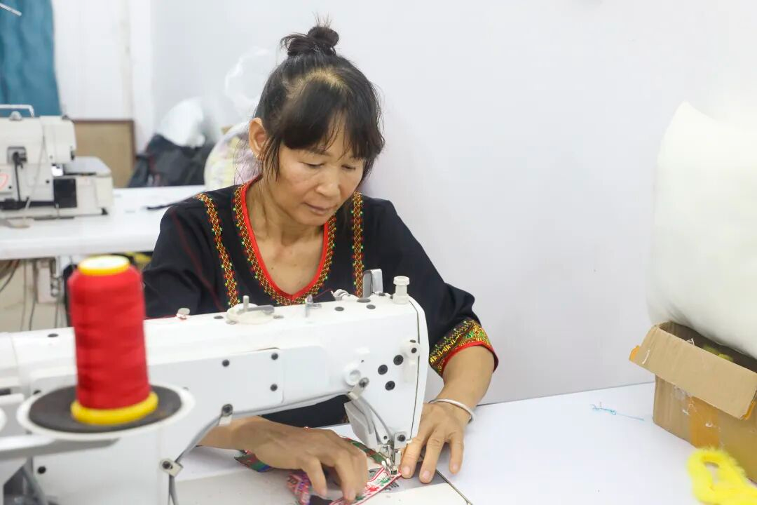 绣娘使用自动绣花机制作黎锦制品。(林佳璐 摄)