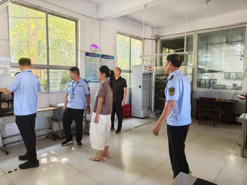 开学前督促学校食堂提前打扫环境卫生、对餐饮具、炊具进行清洗消毒(闫红志 摄)