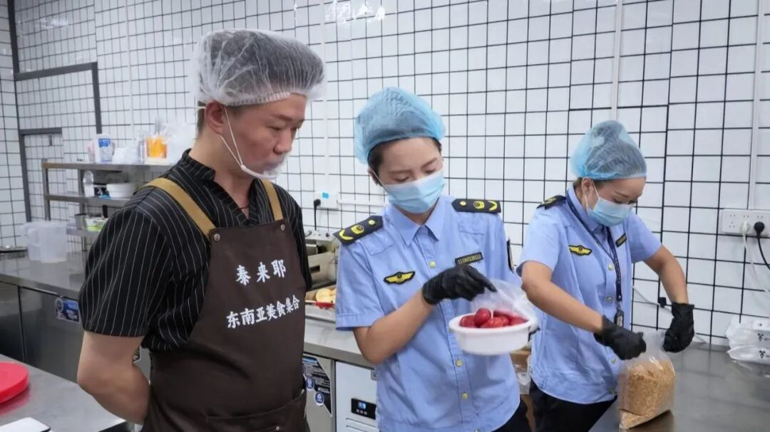 执法人员正在后厨检查食品卫生、品质(王旭 摄)