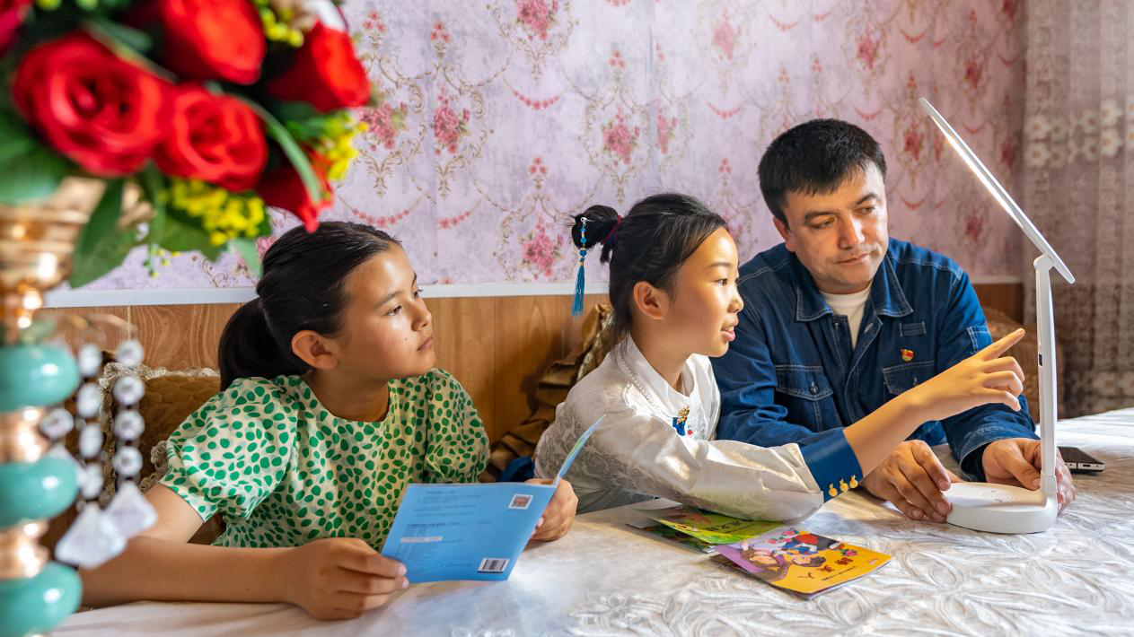 2024年,“一元钱计划”爱心公益项目发起人艾沙江·尼扎木丁向小学生赠送护眼台灯、讲解简单有效的护眼知识。(徐兢兢 摄)