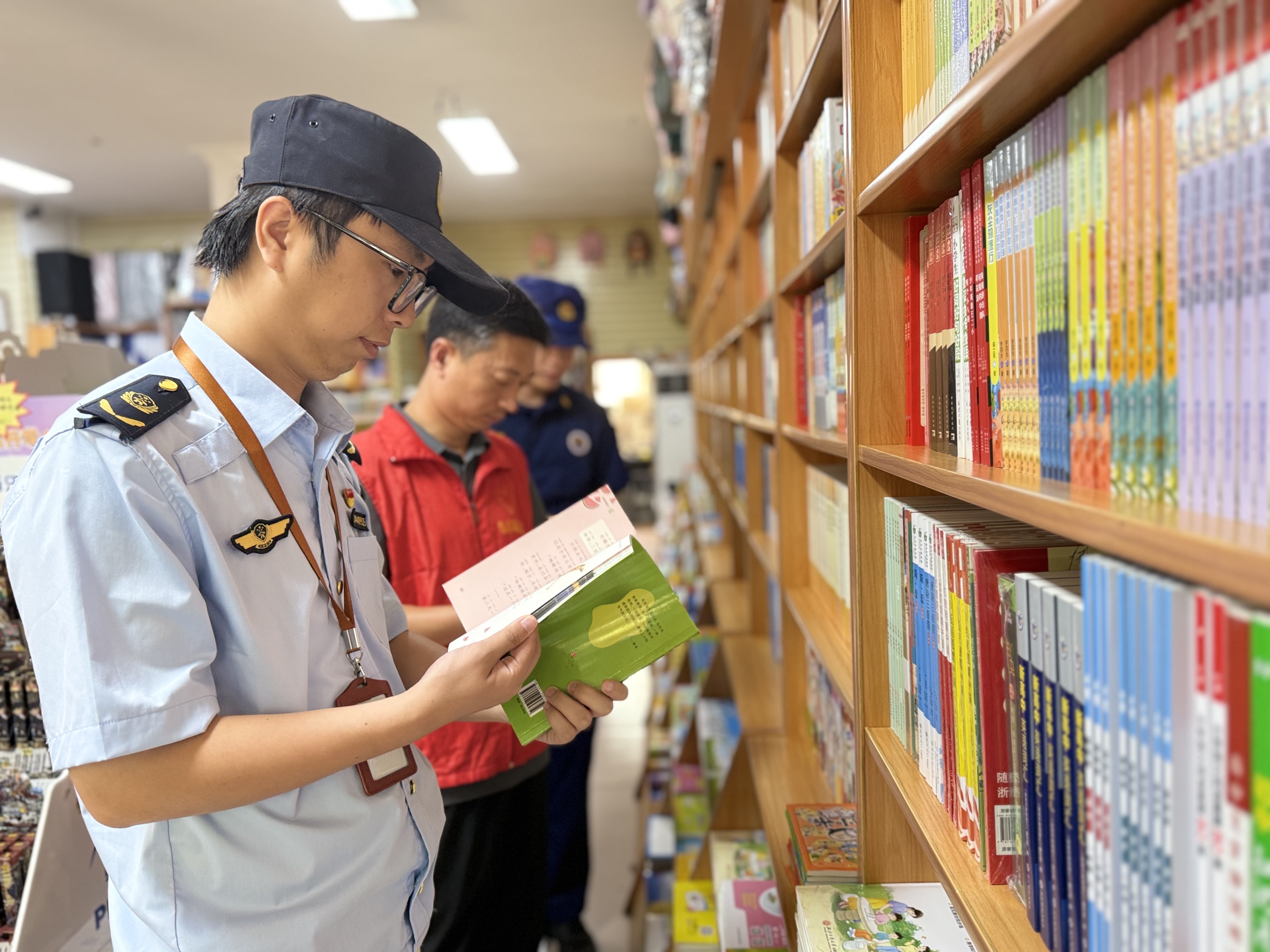 在学校周边商铺,执法人员在清查是否有盗版教辅、非法出版物、危害未成年人身心健康的不良读物出售。(邹静 摄)