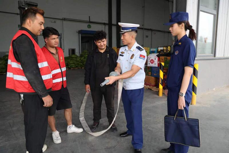 消防监督员们正向企业员工讲解消防器材使用方法(张勇 摄)