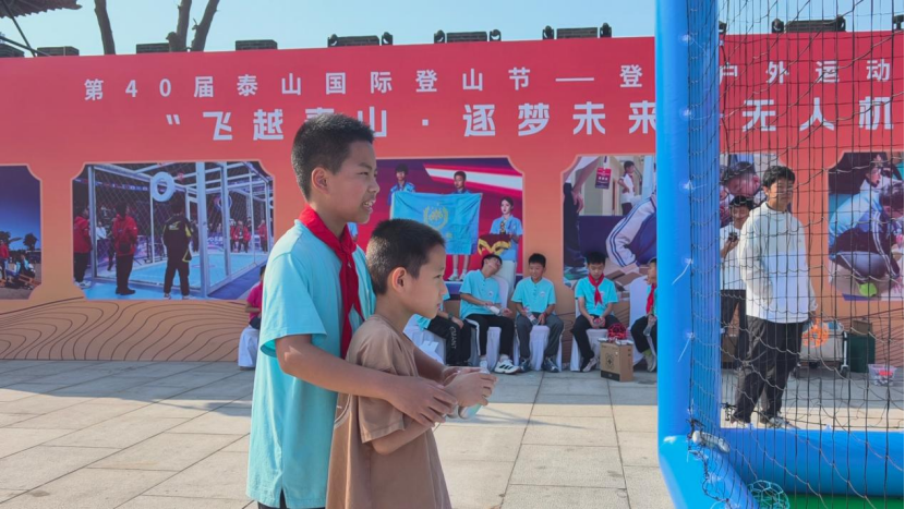 慈明学子手把手指导现场孩童体验无人机(马文军 摄)