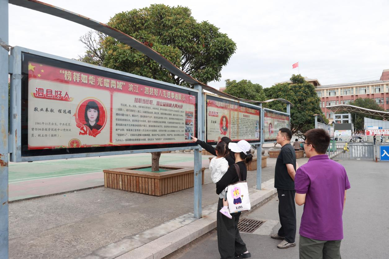 市民在展区前交流观看好人事迹感想。(吴天元 摄)