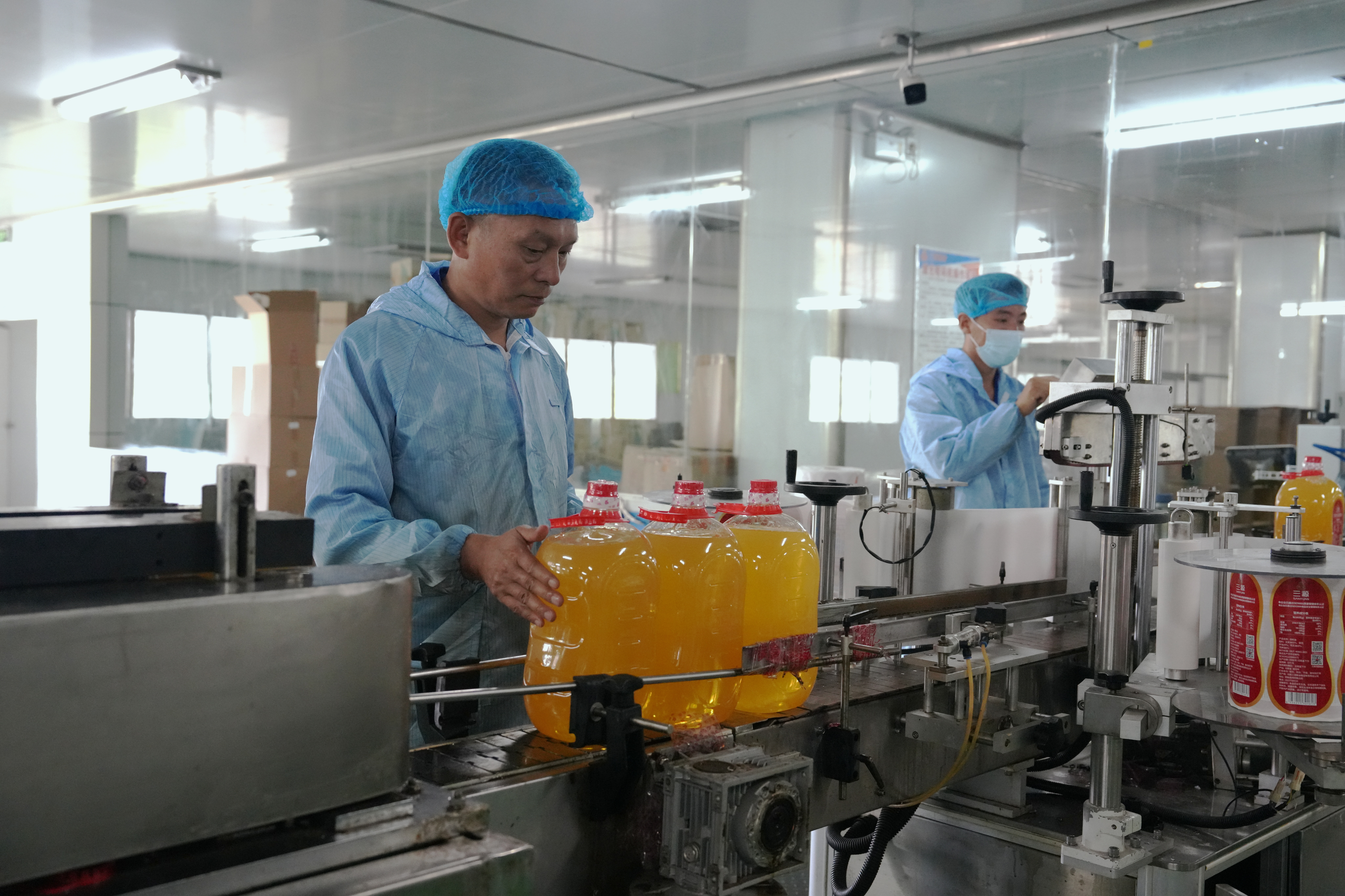 工人在自动化生产线上完成花生油灌装作业(梁可坤 摄)