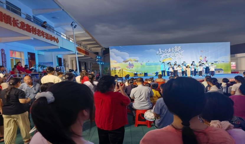 长龙新村在村委会开展群众文艺晚会,组织大学生志愿服务队开展暑期公益课堂成果集中展示