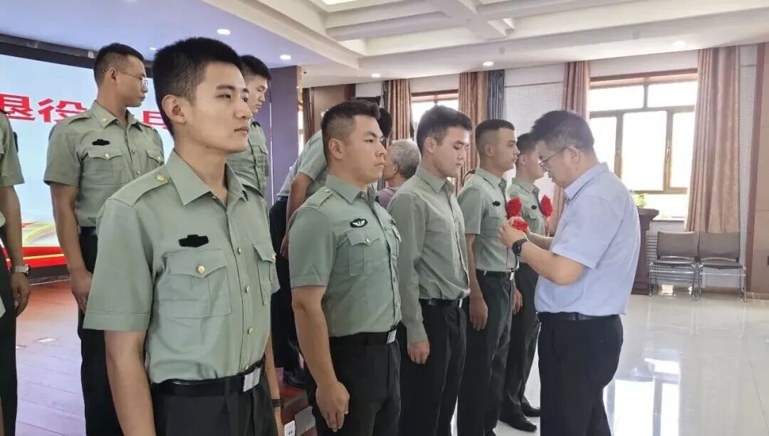 县退役军人事务局领导为返乡退役军人逐一佩戴“光荣返乡”胸花(热比古力·亚森 摄)