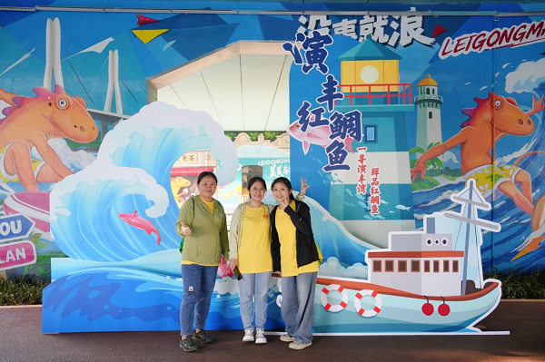 市民在演丰红鲷鱼主题打卡点合影(王聘钊 摄)