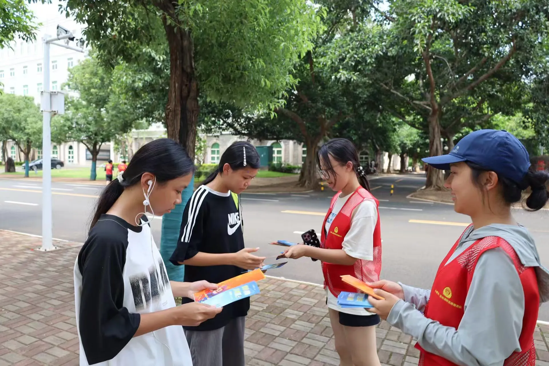 志愿者向学生分发宣传手册(许振群 摄)