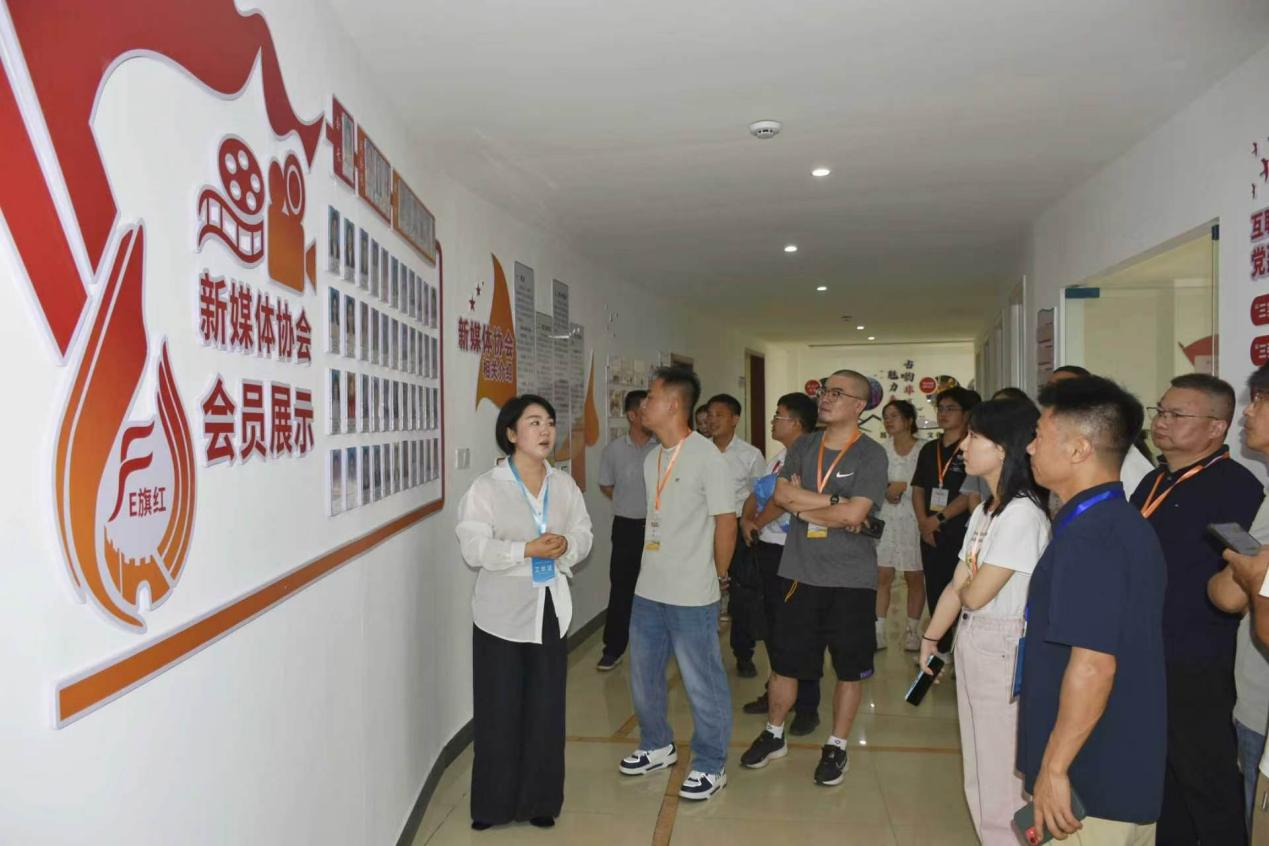 “E旗红”新媒体协会会长龚雪向采风团介绍协会会员展示墙 (吴思雨 摄)
