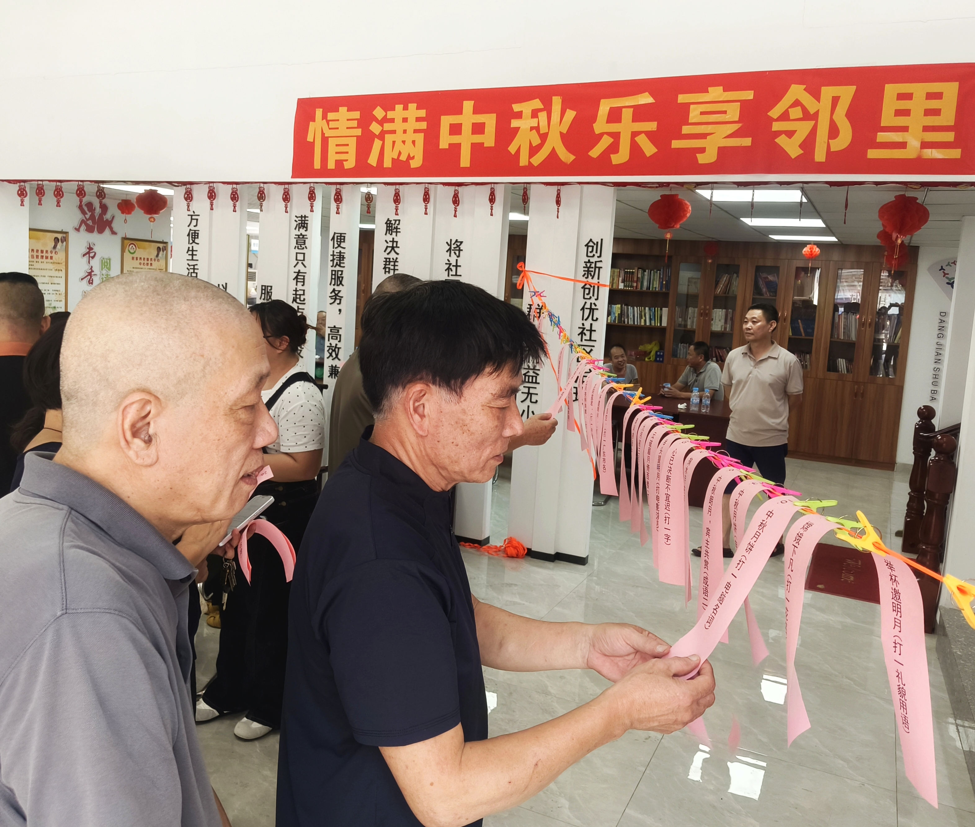 居民们三五成群,驻足浏览谜面。(徐东升摄)