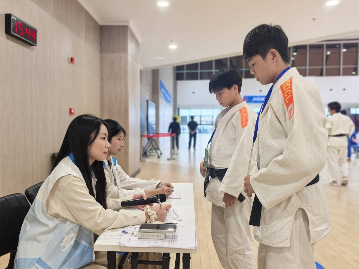 省运会青少年类(体校组)柔道比赛现场,湖北工程学院新技术学院志愿者在核对选手证件。(湖北日报全媒记者 方桐 摄)