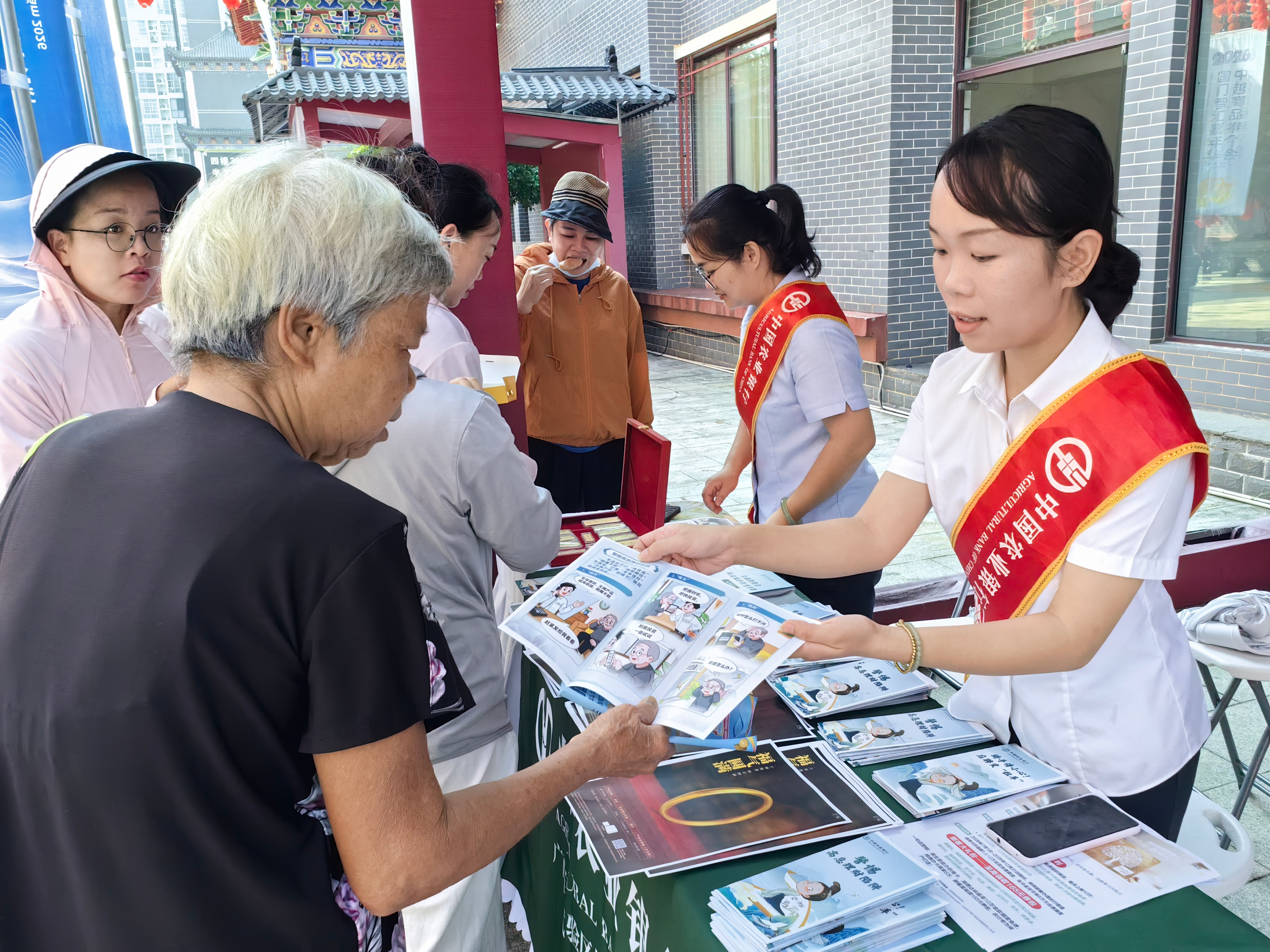 农行凭祥支行工作人员在活动现场向过往群众发放宣传折页场景(欧雪婷 摄)