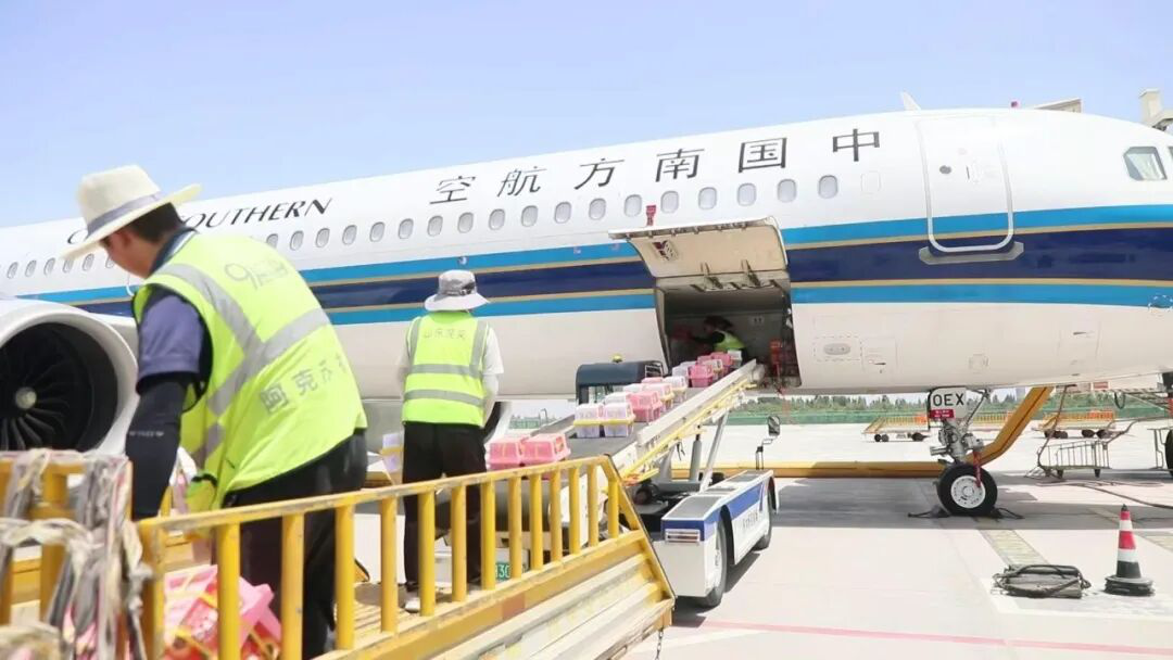 阿克苏红旗坡机场工作人员正往腹舱装载本地特色农产品 (张勇 摄)