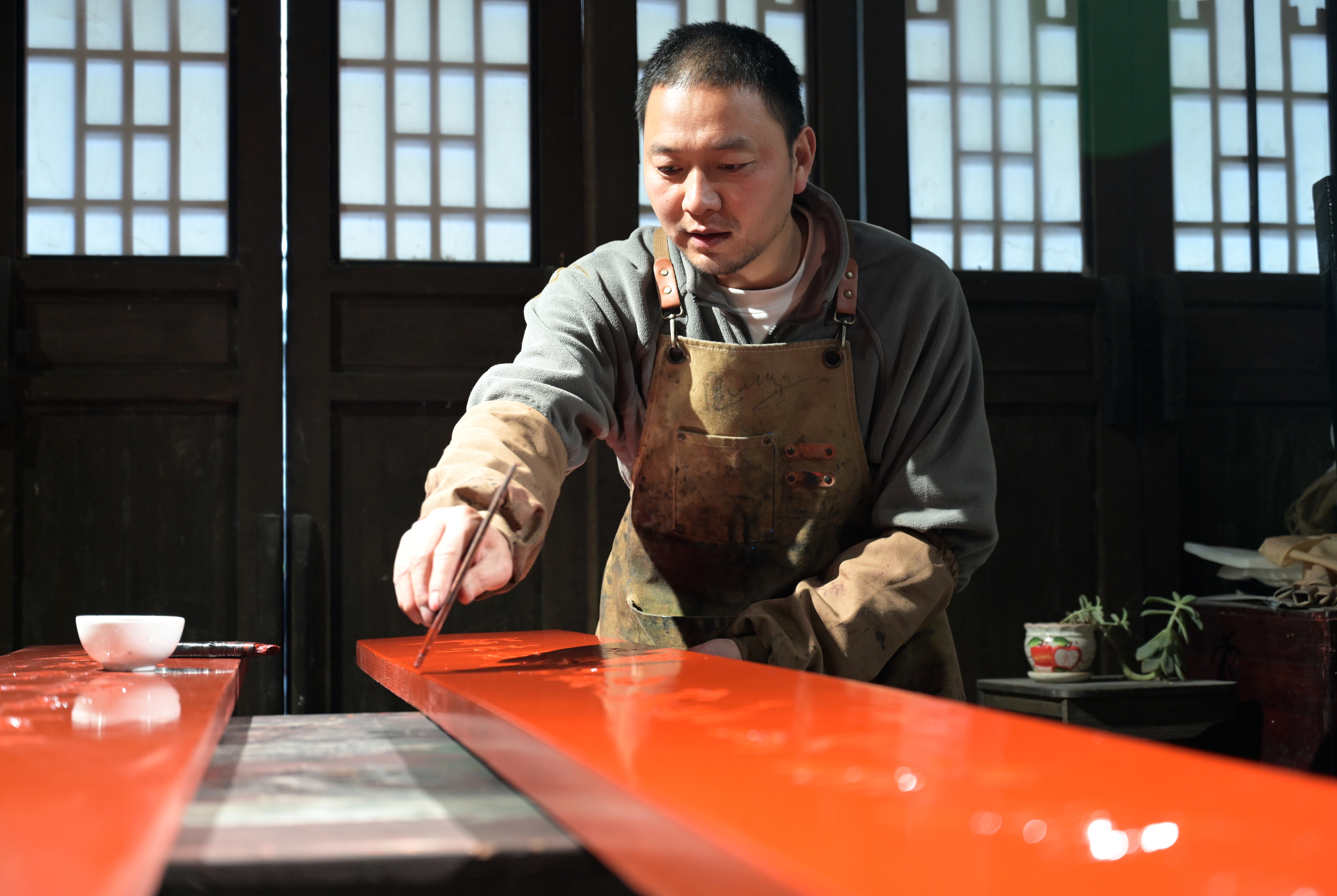 “李氏漆器髹饰技艺”传承人隗鹏正在制作牌匾(徐琦 摄)
