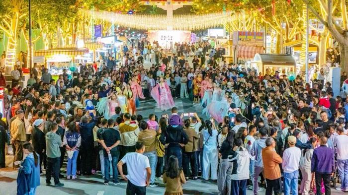 游客们在王三街参与文艺路演互动(上官新宇 摄)