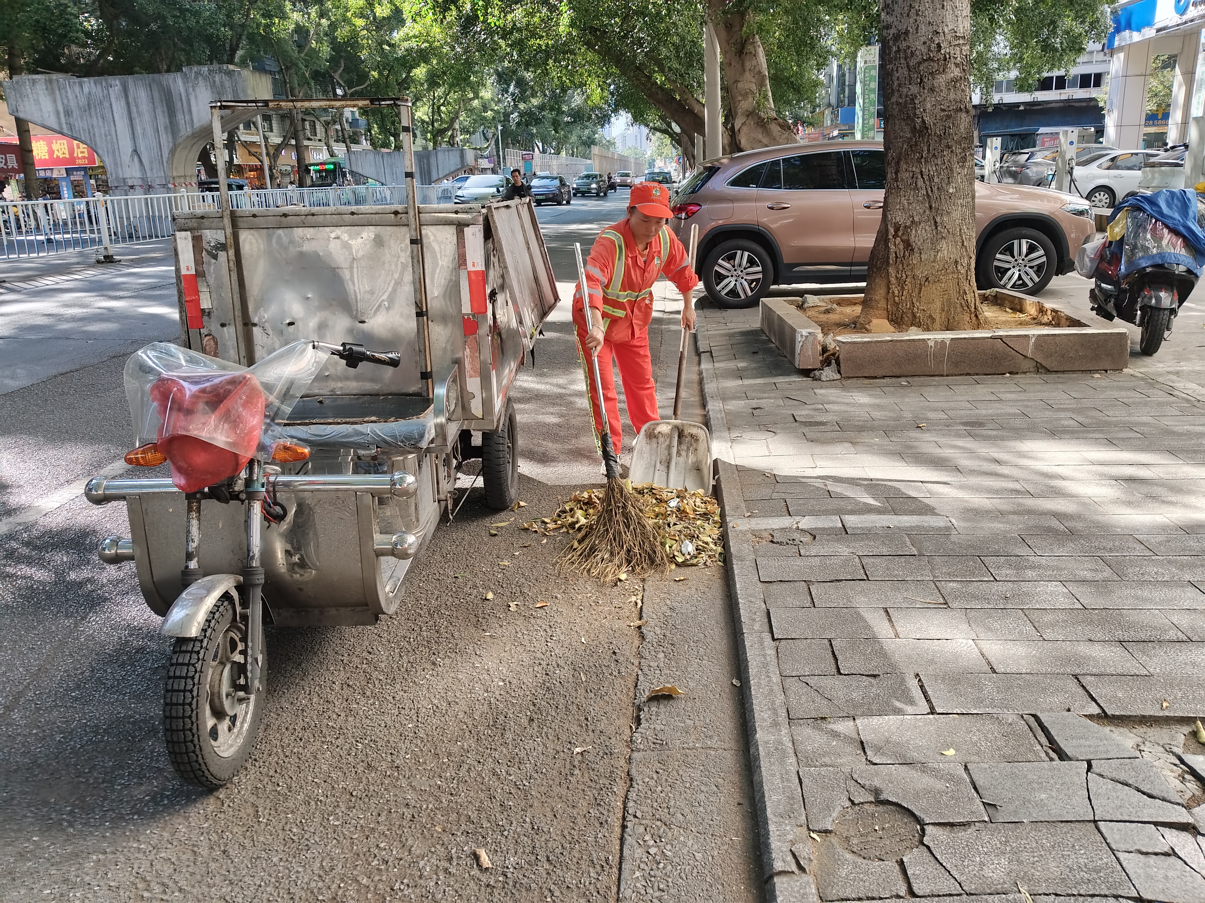 谢金凤正在进行日常保洁,清扫飞鹅路。(刘兴存 摄)