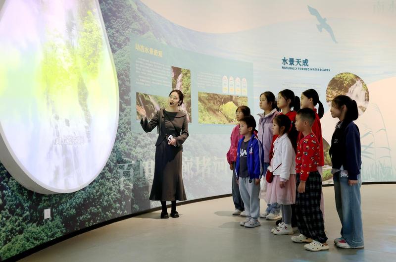 宣讲员程钱英给前来参观的孩子们讲堵河源保护区生态故事(袁海成 摄)