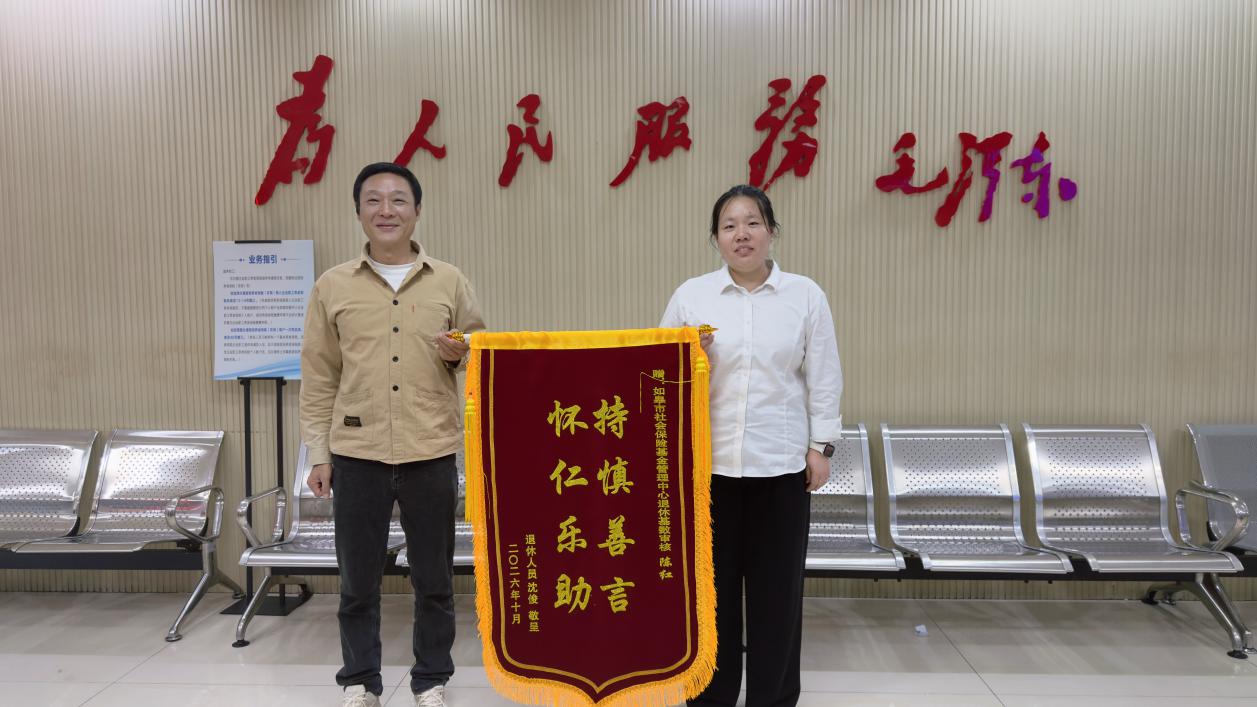 办事群众专程给窗口工作人员陈红送来锦旗 (李瑞 摄)