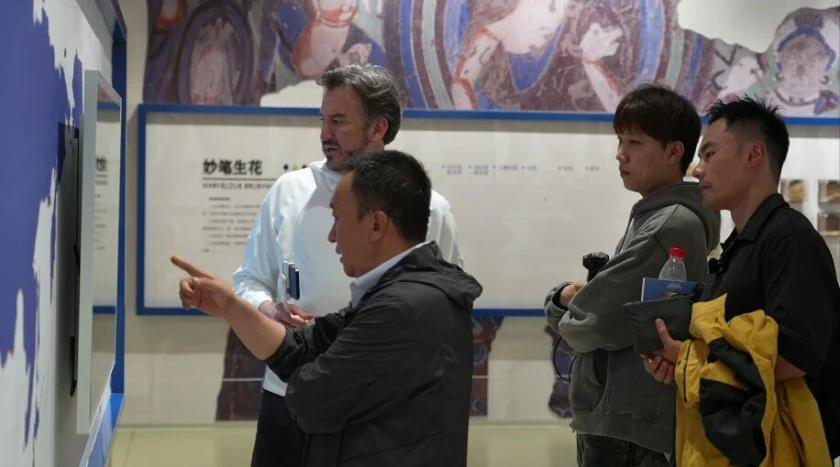 参访团成员在认真观看克孜尔石窟壁画相关资料(尹玲 摄)